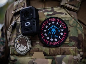 In this file photo taken on Sept. 26, 2020, man wears a "Three Percenter" patch as several hundred members of the Proud Boys and other similar groups gathered for a rally at Delta Park in Portland, Ore.