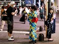 Women in summer kimonos advertise for a bar that stays open after 8 p.m., when most of the restaurants and bars in the Kabukicho nightlife area close due to the state of emergency amid the COVID-19 pandemic, in Tokyo, Japan, Saturday, July 31, 2021.