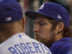 Los Angeles Dodgers starting pitcher Trevor Bauer, right, talks with Dodgers manager Dave Roberts in the dugout against the Washington Nationals in the third inning at Nationals Park in Washington, D.C., July 1, 2021.