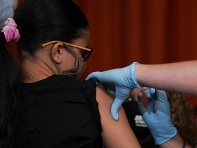 A teen receives a dose of the Pfizer-BioNTech COVID-19 vaccine at a vaccination clinic at Lehman High School in the Bronx borough of New York City, July 27, 2021.
