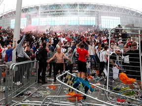 England fans celebrate their first goal while watching the match outside Wembley Stadium in London, July 11, 2021.