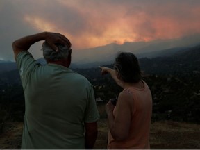 People watch a wildfire in the Larnaca mountain region, Cyprus July 3, 2021. Picture taken July 3, 2021.