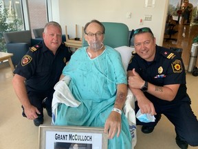 Retired firefighter Grant McCulloch (centre) enjoys a visit from CFB Borden Fire Department Deputy Platoon Chief James Brown (left) and CFB Borden firefighter Jimmy Aubut at Barrie Royal Victoria Hospital on Monday, July 26, 2021.