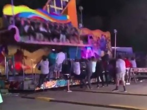 Bystanders at the Cherry Festival in Traverse City, Michigan stop a carnival ride from tipping over.