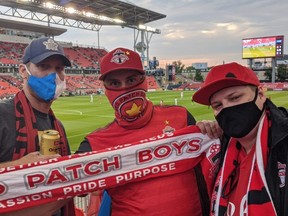 Brad Humber (centre), president of the fan support group Red Patch Boys, takes in the Toronto FC home game with fellow members Josh Glober (left) and Tom Rudan (right) at BMO Field on Saturday, July 17, 2021.