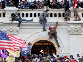 A mob of supporters of U.S. President Donald Trump fight with members of law enforcement at a door they broke open as they storm the U.S. Capitol Building in Washington, U.S., January 6, 2021.