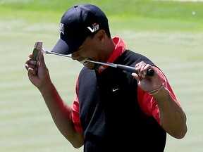 Tiger Woods bites his putter following a putt on the 18th hole during the final round of the Arnold Palmer Invitational presented by MasterCard at the Bay Hill Club and Lodge on March 25, 2013 in Orlando, Florida.