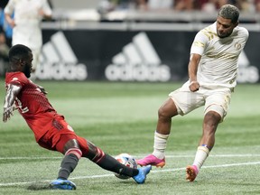 Atlanta United forward Josef Martinez battles for the ball against Toronto FC defender Kemar Lawrence.