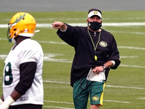 Edmonton Elks head coach Jaime Elizondo wears a mask during training camp.