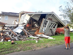 Dartanian Stovall looks at the house that collapsed with him inside during the height of Hurricane Ida in New Orleans, Louisiana, U.S., August 30, 2021. Stovall said he was inside the house he was renovating on Lasalle Street in the Uptown neighborhood when the chimney collapsed and the rest of the house followed. He managed to crawl to safety. Michael DeMocker/USA TODAY Network via REUTERS  THIS IMAGE HAS BEEN SUPPLIED BY A THIRD PARTY. MANDATORY CREDIT