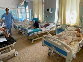 Wounded Afghan men receive treatment at a hospital after yesterday's explosions outside airport in Kabul, Afghanistan Aug. 27, 2021.