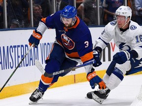 Islanders defenceman Adam Pelech (left) skates behind the net defended by Lightning left wing Ondrej Palat (right) during Game 4 of the 2021 Stanley Cup Semifinals at Nassau Veterans Memorial Coliseum in Uniondale, N.Y., June 19, 2021.