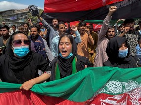 People carry the national flag at a protest held during the Afghan Independence Day in Kabul, Afghanistan August 19, 2021.