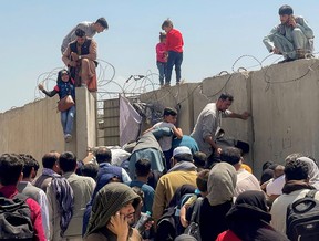 A man pulls a girl to get inside Hamid Karzai International Airport in Kabul, Afghanistan August 16, 2021. REUTERS/Stringer