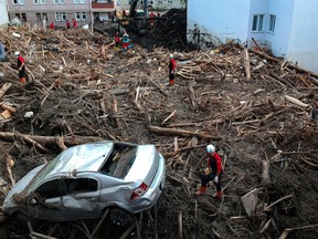 Rescuers looks through the debris following flash floods in the town of Bozkurt in the district of Kastamonu, in the Black Sea region of Turkey on August 15, 2021.