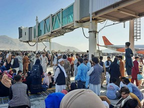 Afghans crowd at the tarmac of the Kabul airport on August 16, 2021, to flee the country as the Taliban were in control of Afghanistan after President Ashraf Ghani fled the country and conceded the insurgents had won the 20-year war.