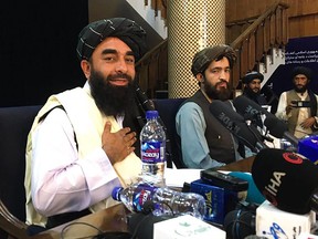 Taliban spokesperson Zabihullah Mujahid, left, attends the first press conference in Kabul on August 17, 2021, following their takeover of Afghanistan.