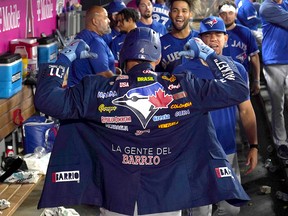 Toronto Blue Jays centre fielder George Springer (4) poses with the team’s La Gente Del Barrio jacket after hitting a solo home run against the Los Angeles Angels  at Angel Stadium.