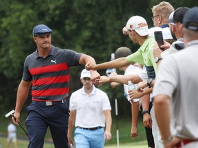 Bryson DeChambeau greets fans as he walks to the fifth tee from the fourth green during the final round of the BMW Championship at Caves Valley Golf Club in Owings Mills, Maryland, Sunday, Aug. 29, 2021.