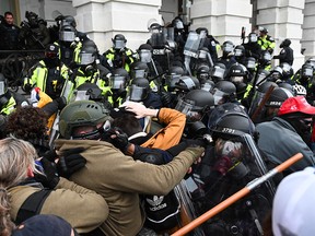 Riot police push back a crowd of supporters of U.S. President Donald Trump after they stormed the Capitol building in Washington, D.C., Jan. 6, 2021.