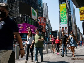 Some people wear masks around Times Square, as cases of the infectious coronavirus Delta variant continue to rise in New York City, New York, U.S., July 23, 2021.