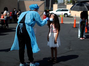 A young girl is given a COVID-19 test at a back-to-school clinic in South Gate, Los Angeles, Calif., Aug. 12, 2021.