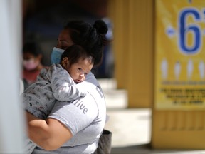 A woman with a child attends a COVID-19 vaccination clinic in Los Angeles, Calif., Aug. 11, 2021.