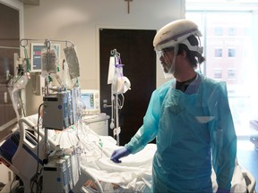 A nurse works in a COVID-19 patient's room during a tour of SSM Health St. Anthony Hospital's intensive care unit (ICU) amid the COVID-19 pandemic in Oklahoma City, Okla., Aug. 24, 2021.