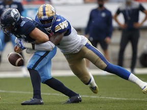 Winnipeg Blue Bombers defensive lineman Willie Jefferson, right, forces the fumble as he sacks Toronto Argonauts quarterback Nick Arbuckle during first half CFL football action in Toronto, Saturday, Aug. 21, 2021.