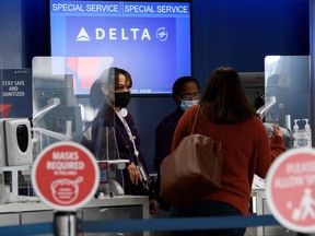 Passengers check bags for a Delta Air Lines, Inc. flight during the COVID-19 pandemic at Los Angeles International Airport (LAX) in Los Angeles, Nov. 18, 2020.