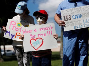 Supporters of wearing masks in schools Sofia Deyo 11, and her brother Matthew Deyo 6, protest outside the Pinellas County Schools Administration Building in Largo, Fla., Aug. 9, 2021.
