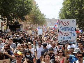 Protesters hold up banners and placards during a nationwide protest against France's new COVID-19 health pass in Marseille, Saturday, Aug. 7, 2021.