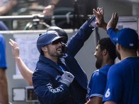 Blue Jays' Randal Grichuk is congratulated by teammates in the dugout after hitting a two-run home run off of starting pitcher Logan Gilbert of the Seattle Mariners during the second inning of a game at T-Mobile Park on Aug. 15, 2021 in Seattle, Wash.