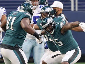 Vinny Curry, right, and Fletcher Cox of the Philadelphia Eagles celebrate after a sack in the first quarter against the Dallas Cowboys at AT&T Stadium on Dec. 27, 2020 in Arlington, Texas.