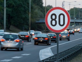 Speed limit sign with a traffic in the background