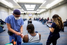 A health-care worker from Humber River hospital's mobile vaccination team administers the Moderna COVID-19 vaccine at The Church of Pentecost Canada in Toronto, May 4, 2021.