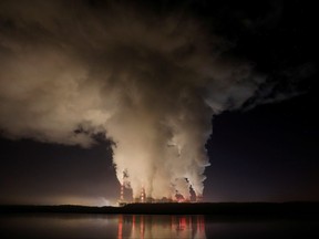 Smoke and steam billows from Belchatow Power Station, Europe's largest coal-fired power plant operated by PGE Group, at night near Belchatow, Poland, Dec. 5, 2018.