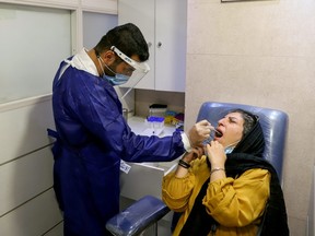 A medical staff member performs a PCR test as COVID-19 cases spike, in Tehran, Iran, July 28, 2021.