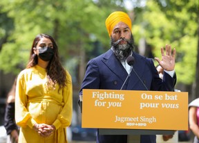 New Democratic Party leader Jagmeet Singh speaks to the press as his wife Gurkiran Kaur Sidhu looks on after Prime Minister Justin Trudeau called an early election, in Montreal, Aug. 15, 2021.