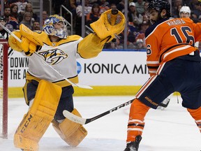 The Nashville Predators' goalie Juuse Saros makes a glove save in front of the Edmonton Oilers' Jujhar Khaira during first period NHL action at Rogers Place, in Edmonton, Feb. 8, 2020.