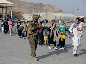 This handout photo shows U.S. Marines assigned to 24th Marine Expeditionary Unit escorting evacuees at Hamid Karzai International Airport, Kabul, Afghanistan, August 18, 2021.