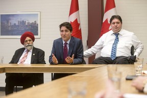 Prime Minister Justin Trudeau sits next to Darshan Kang and Kent Hehr in downtown Calgary, Alta., on Tuesday, March 29, 2016.