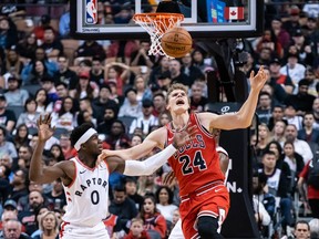 Chicago Bulls forward Lauri Markkanen battles for the loose ball against Toronto Raptors guard Terence Davis during the first half at Scotiabank Arena in Toronto, Oct. 13, 2019.