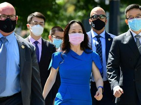 In this file photo taken on Aug. 4, 2021, Huawei chief financial officer Meng Wanzhou arrives at British Columbia Supreme Court with her security detail for the afternoon session of her extradition hearing in Vancouver.