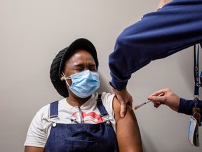 A healthcare worker, Ruben Rodriguez, from Humber River hospital's mobile vaccination team administers the Moderna COVID-19 vaccine to Anita Addei at The Church of Pentecost Canada on May 4.