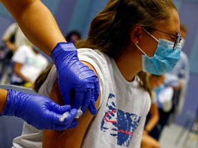 A nurse administers the first dose of the Moderna vaccine against COVID-19 to 15-year-old Tatiana Suarez at a vaccination centre in Meloneras on the island of Gran Canaria, Spain, July 28, 2021.