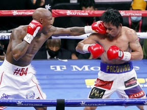 Yordenis Ugas (left) hits Manny Pacquiao in the sixth round of their WBA welterweight title fight at T-Mobile Arena in Las Vegas, Saturday, Aug. 21, 2021.