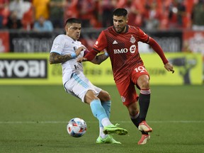 Toronto FC midfielder Alejandro Pozuelo (10) dribbles the ball past New England Revolution Gustavo Bou on Saturday night at BMO Field.