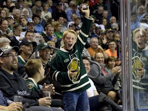 London Knights fan Noel Melady, 12, celebrates after catching a wayward puck during their OHL regular season hockey home opener against the Plymouth Whalers at Budweiser Gardens in London, Ont. on Friday September 26, 2014. Craig Glover/London Free Press/QMI Agency