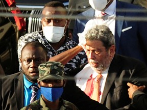 St. Vincent and the Grenadines Prime Minister Ralph Gonsalves, his shirt covered in blood, is evacuated after media reported that he was hit by a stone during a protest in Kingstown, St. Vincent and the Grenadines August 5, 2021.